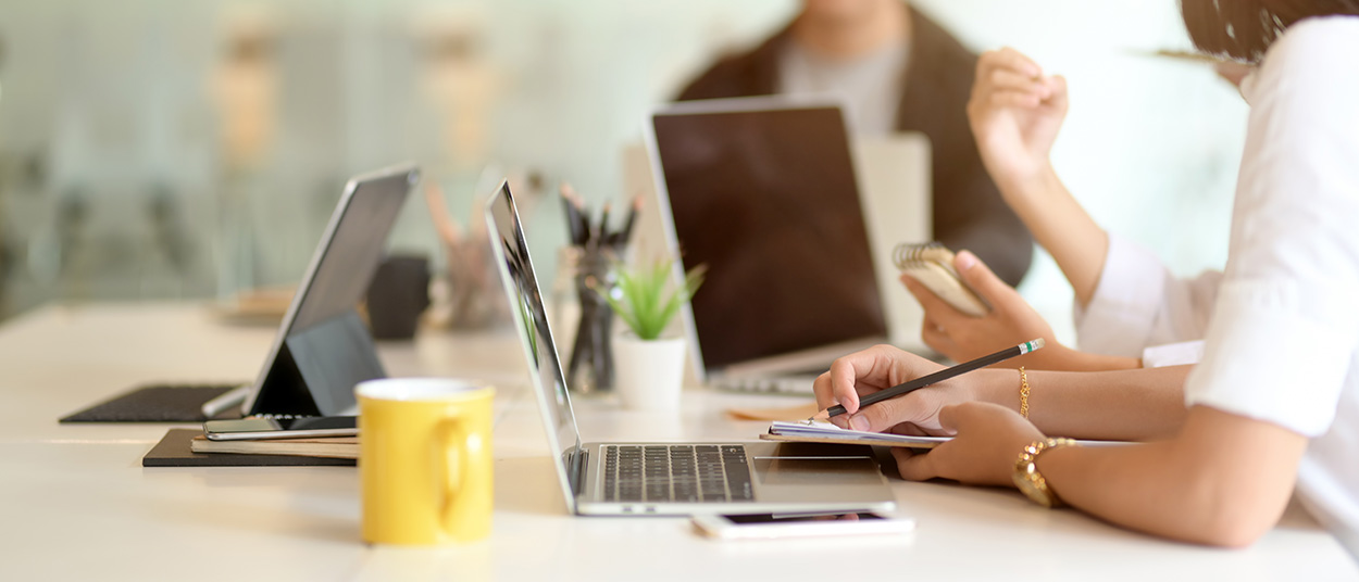 Businesspeople meeting on their project with digital device and office supplies on white desk